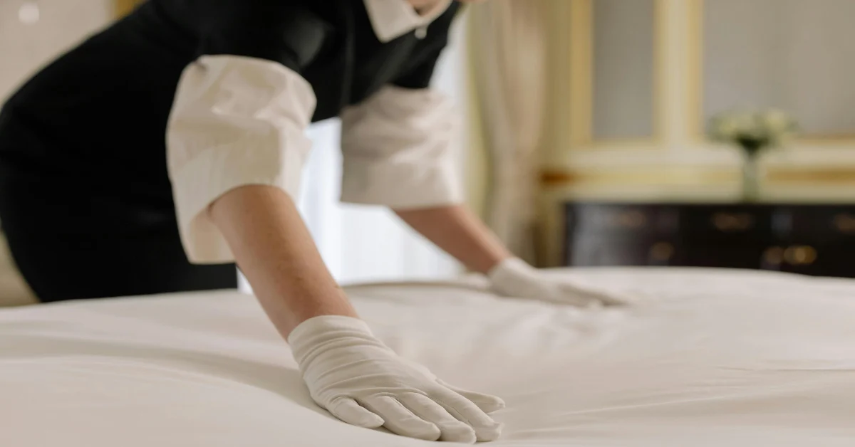 A maid fixing the bed sheets