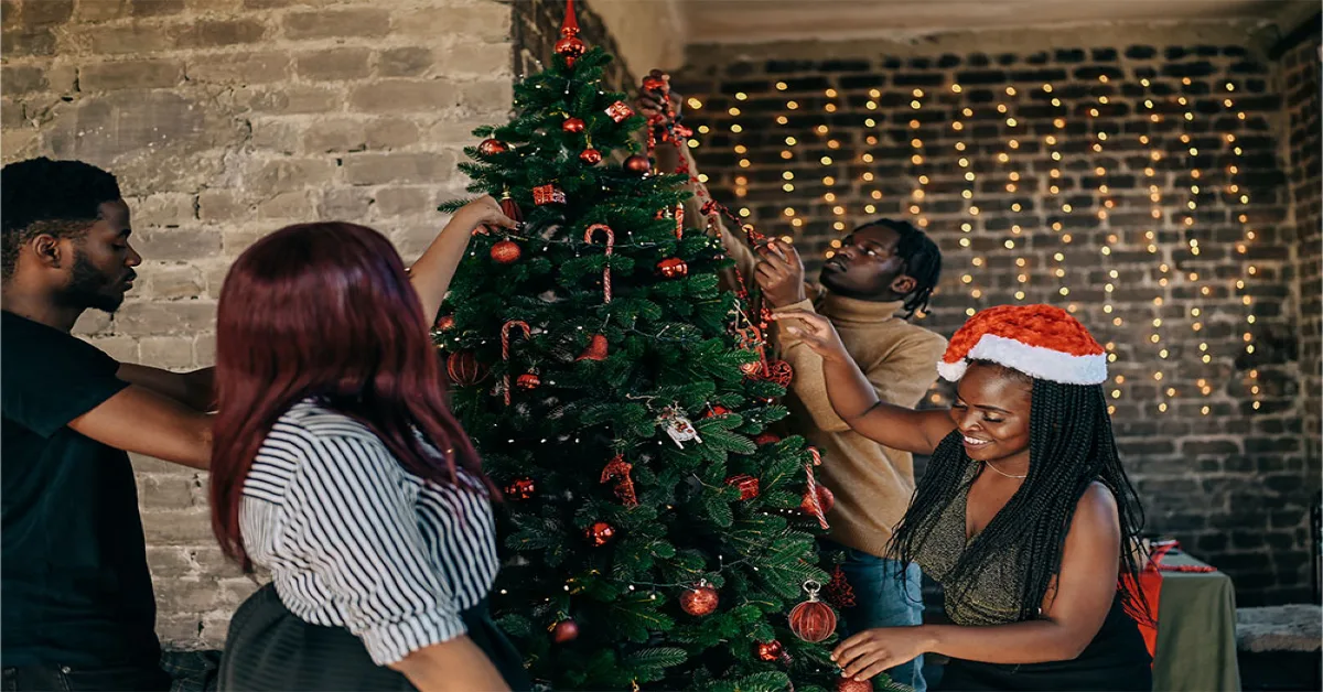 People decorating Christmas tree