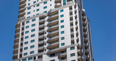 A close-up image of a tall residential skyscraper featuring multiple floors
