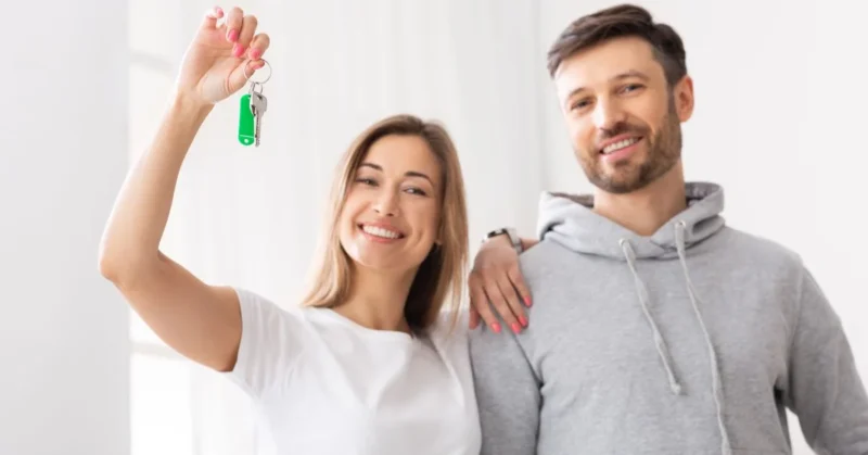 A couple holding a key after buying a property in Dubai