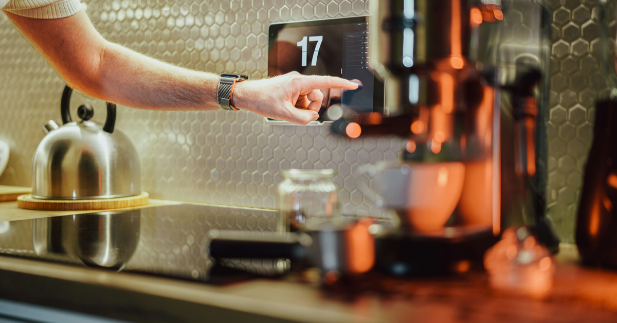 A man adjusting his home’s temperature using a smart thermostat