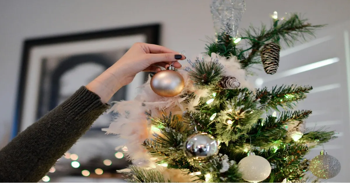 A woman Holding Beige Bauble Near Christmas Tree
