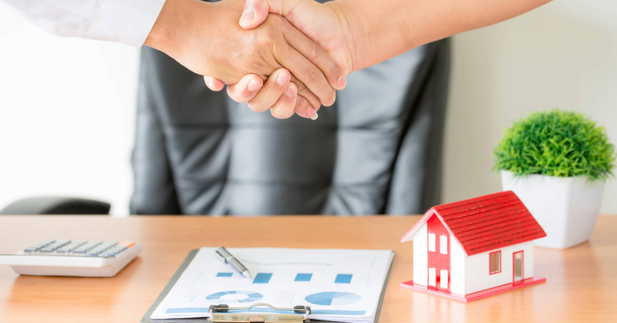 Hands of agent and client shaking hands after signed contract