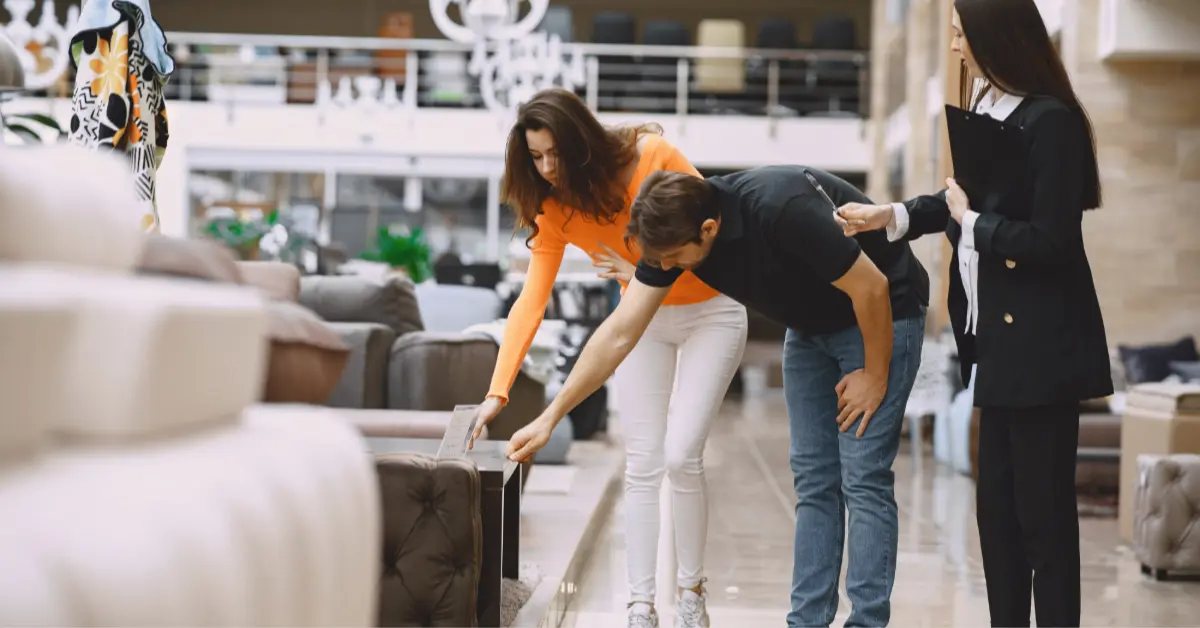 Couple with salesman in furniture store