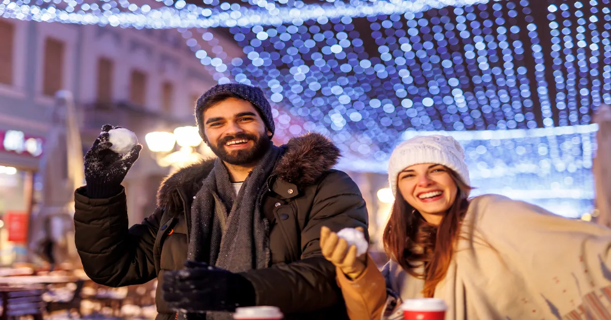 Couple having snowball fight while celebrating Christmas outdoors