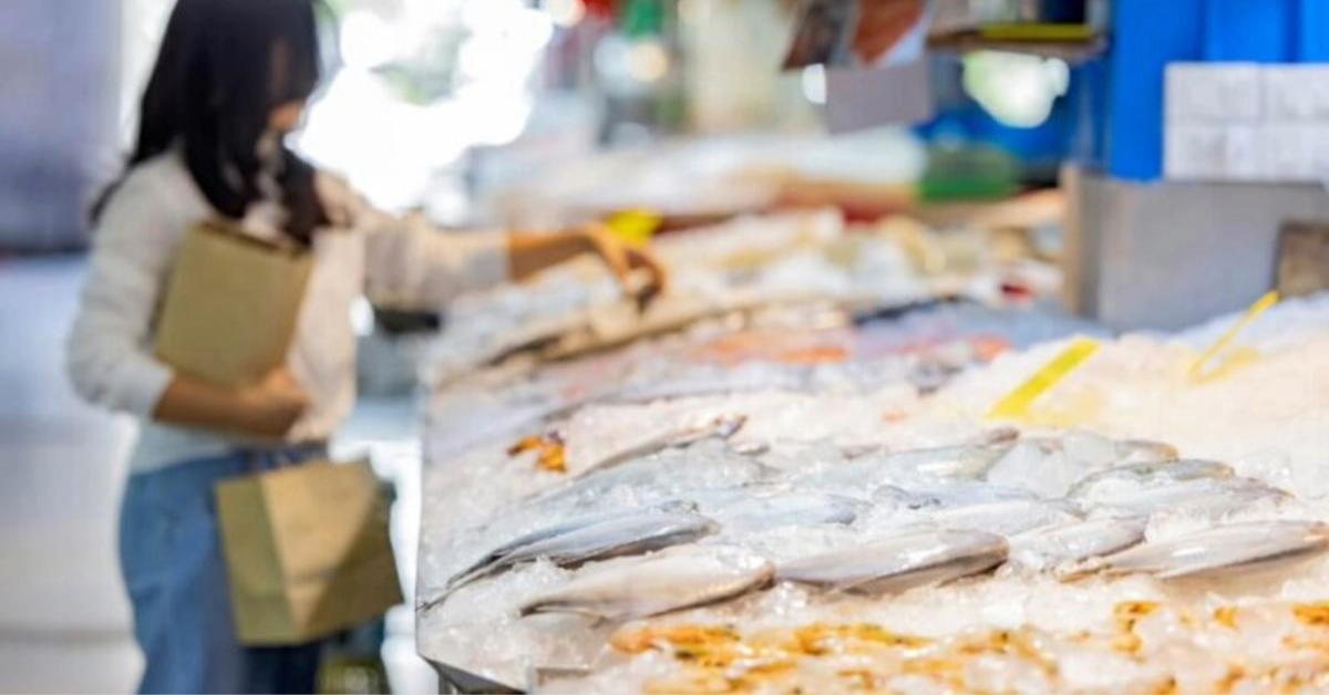 A woman buying fish in a fish market