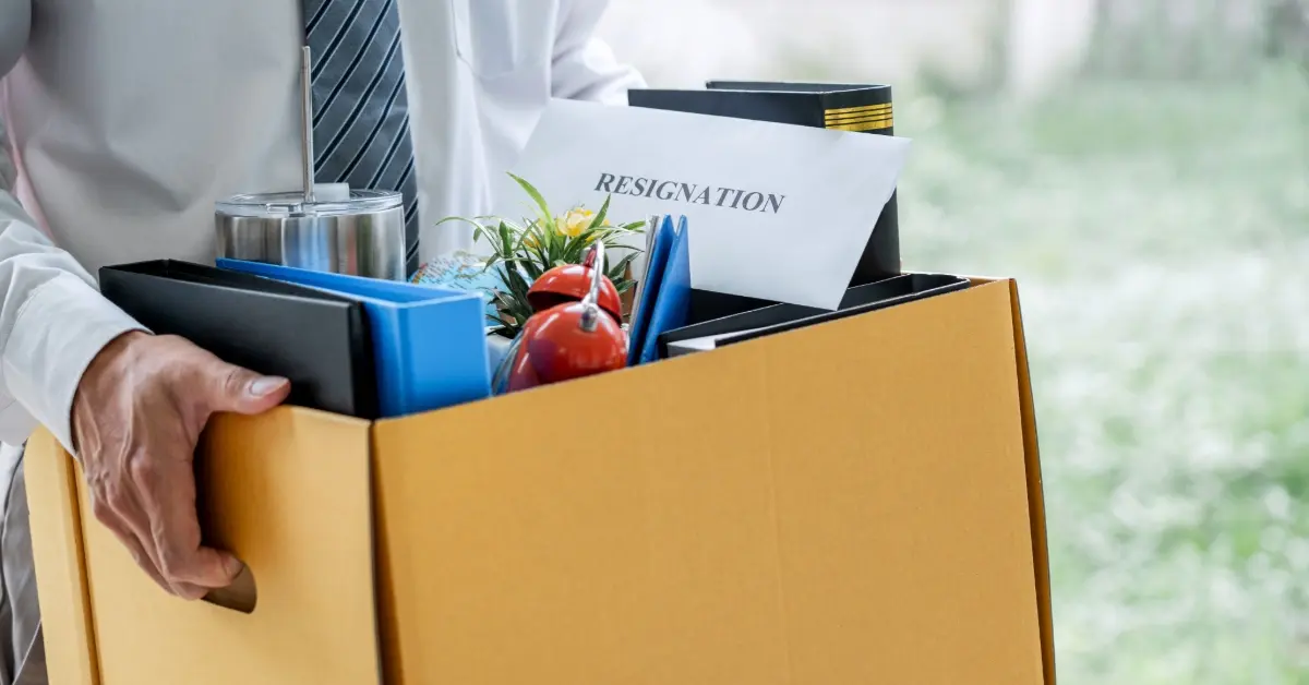 A man carrying a box of office supplies after resigning