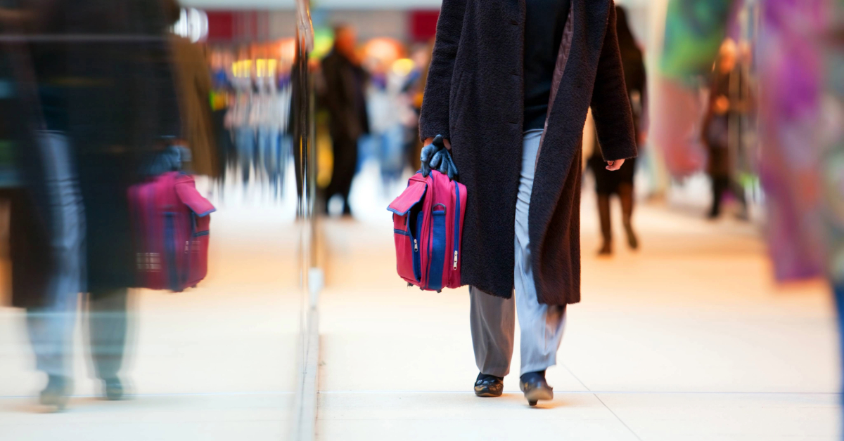 A woman walking through the mall carrying shopping bags