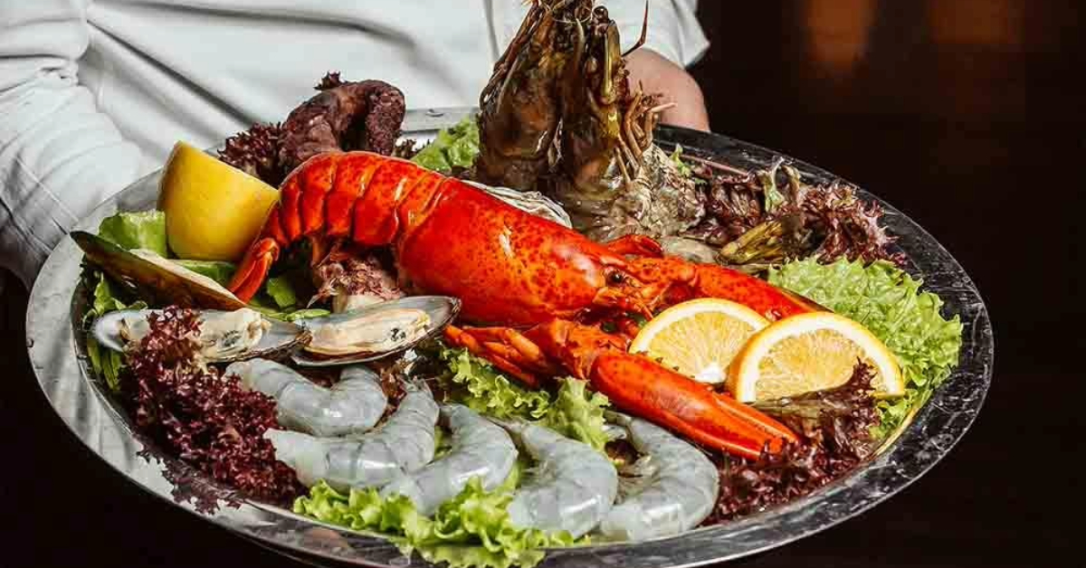 A chef serving a plate of lobster