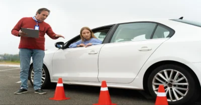 A driving instructor guiding a learner through traffic rules.