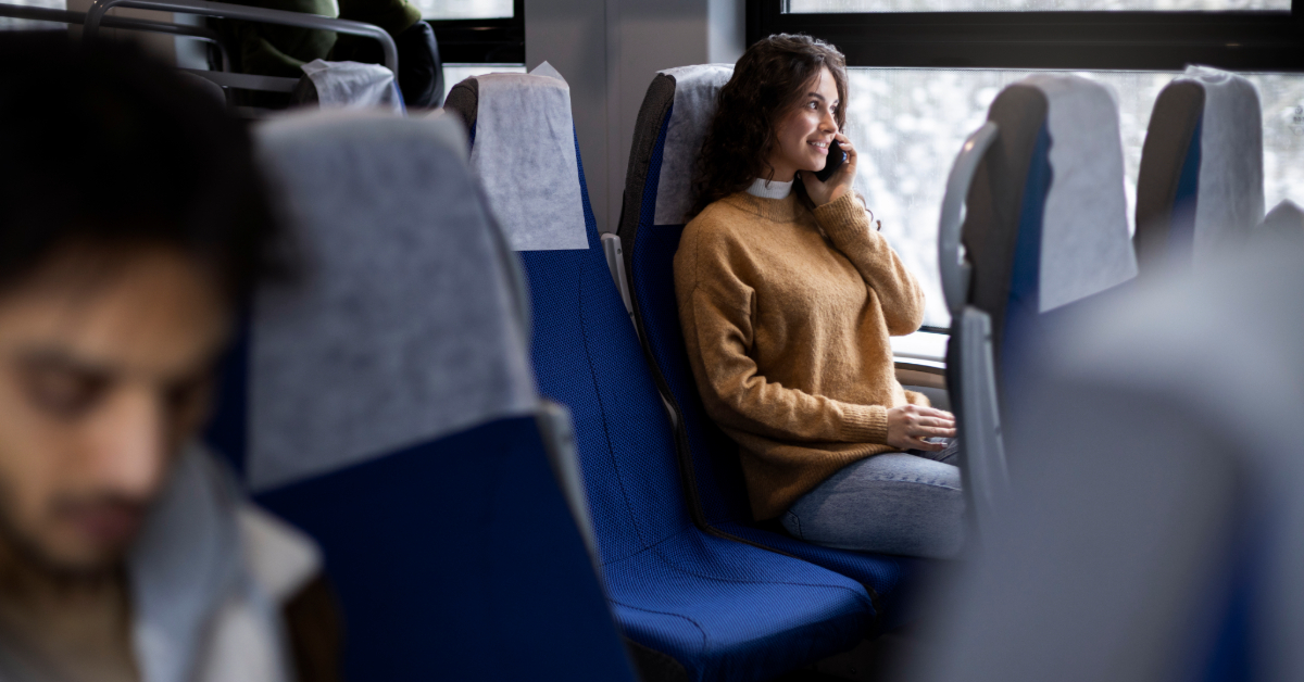 A woman talking on a phone while sitting on a bus