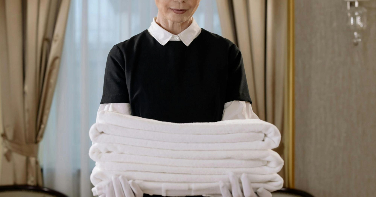 A maid Holding a Stack of Towels