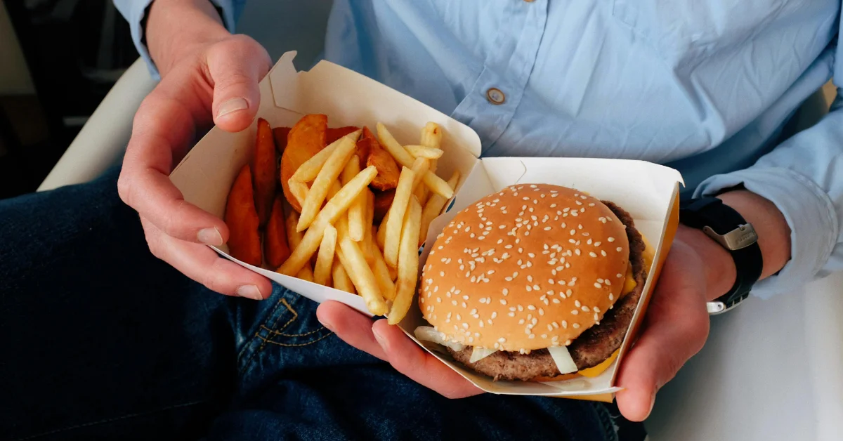 Man holding a burger and fries