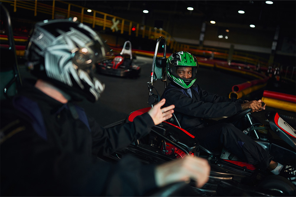 People karting with helmets on a go kart track
