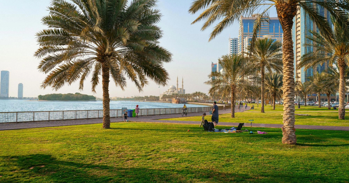 A wide-angle view of Al Mahatta Park showing the green lawns