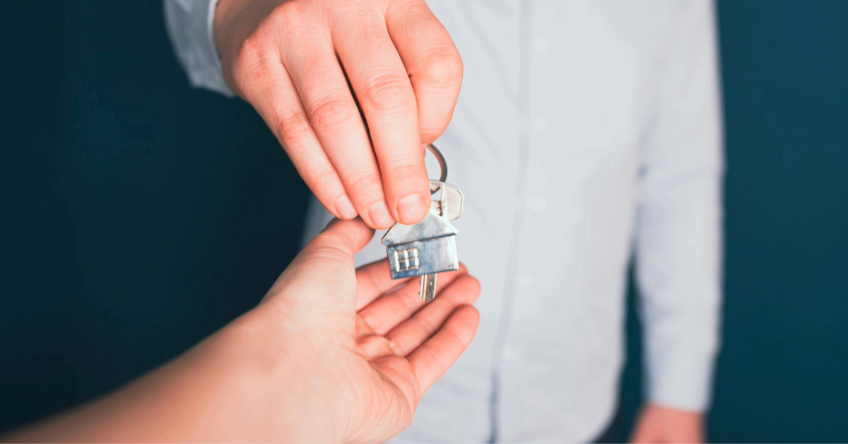 A person handling a key to a property