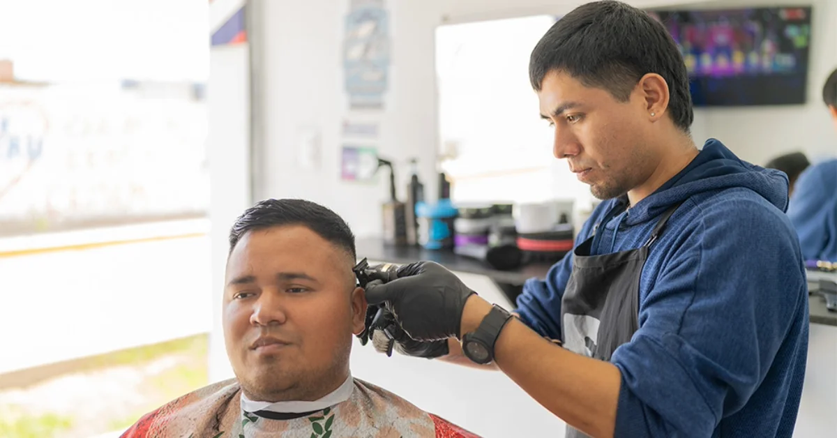 A man getting a haircut in one of the best barber shops in Sharjah