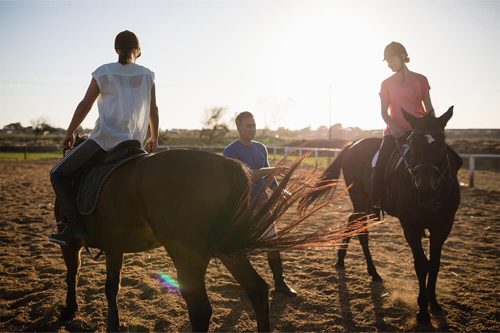 Trainer at Ambition Equestrian Club guiding how to ride a horse