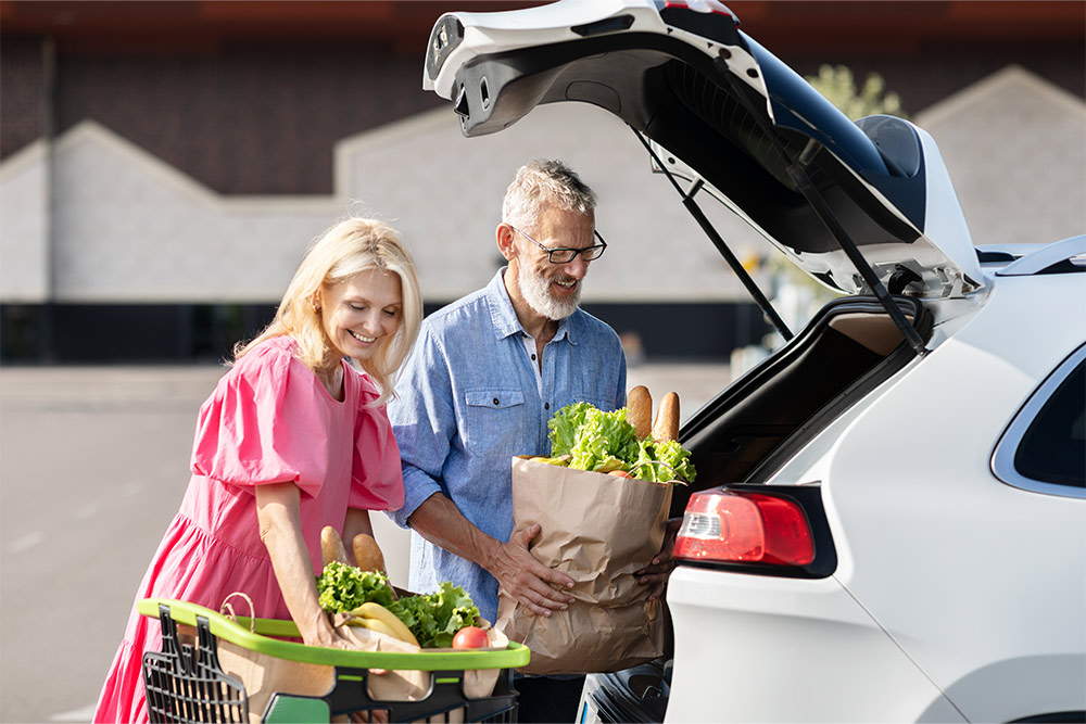 Senior couple loading groceries in the car after shopping 