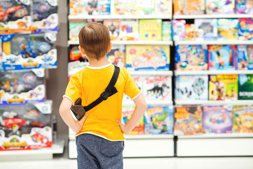 A boy thinking of what to buy at a toy shop in Sharjah 