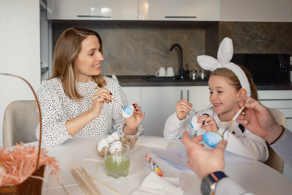A mother and daughter painting eggs for Easter in Duba