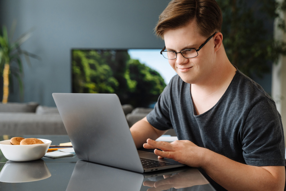 A man with special abilities working on his laptop