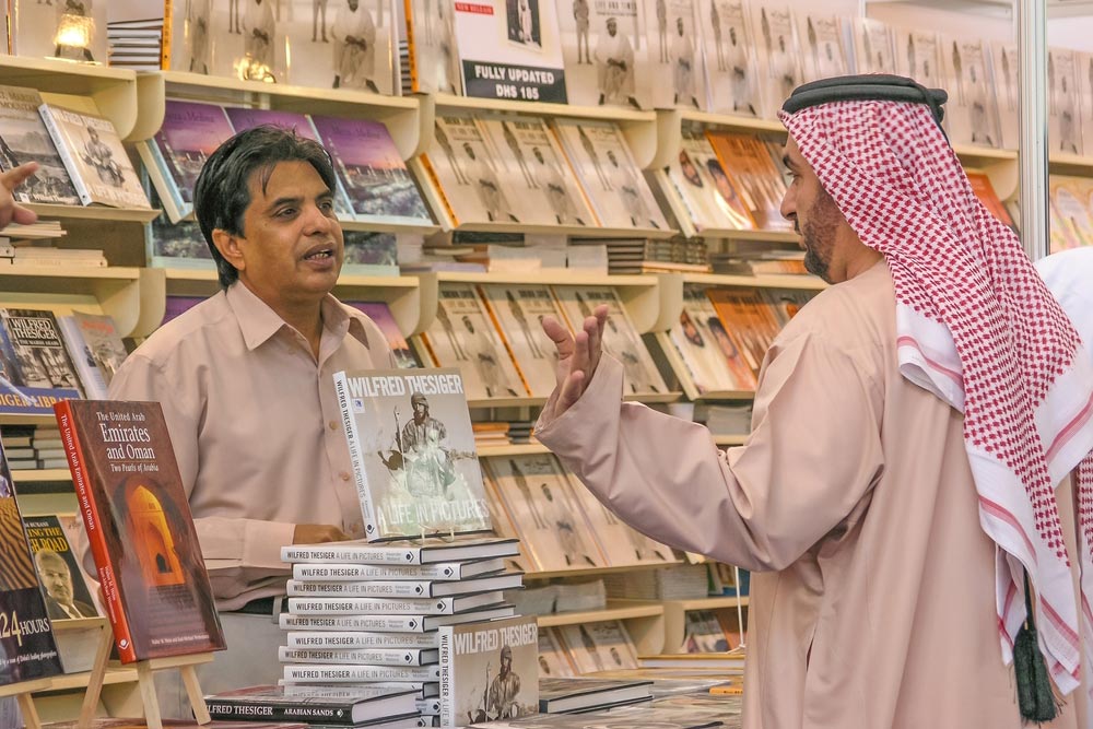 a man buying book from a shop in Sharjah