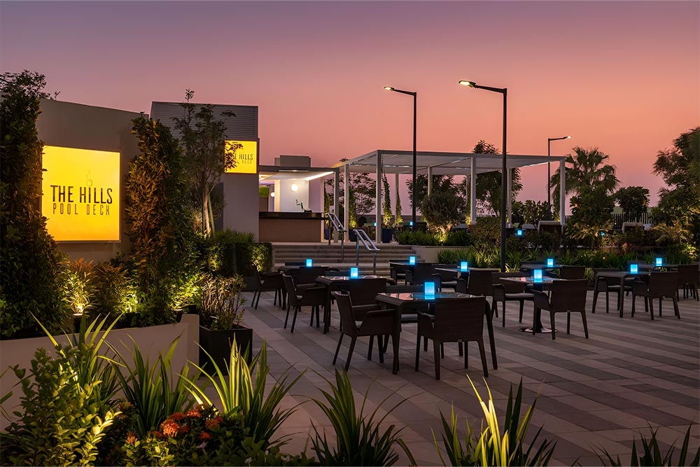 Outdoor terrace dining of the Hills Pool Deck at Damac Hills in Dubai