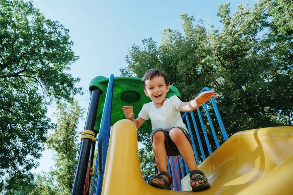 A kid playing on a slide in a park