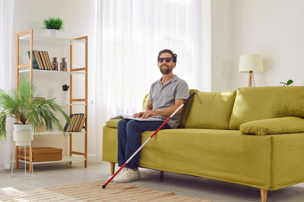 A visually impaired man seated on a couch