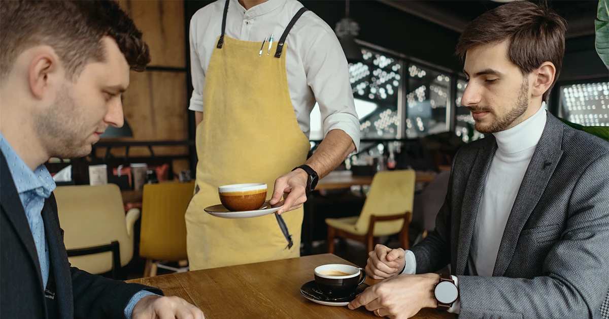 A waiter serving coffee in a cafe in Dubai Creek 