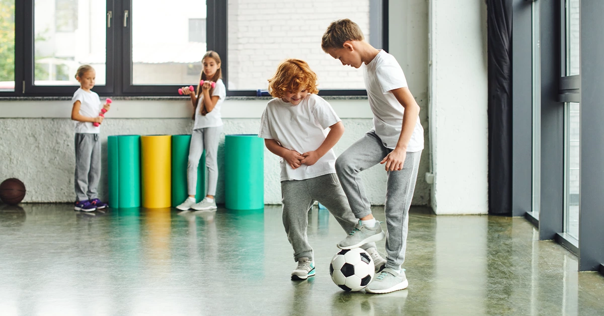 Kids playing football in an indoor play area 