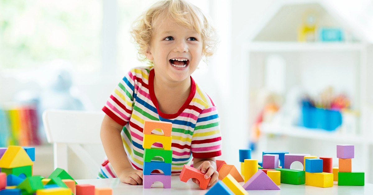 A kid playing with colourful toy blocks at the best nursery in Jumeirah
