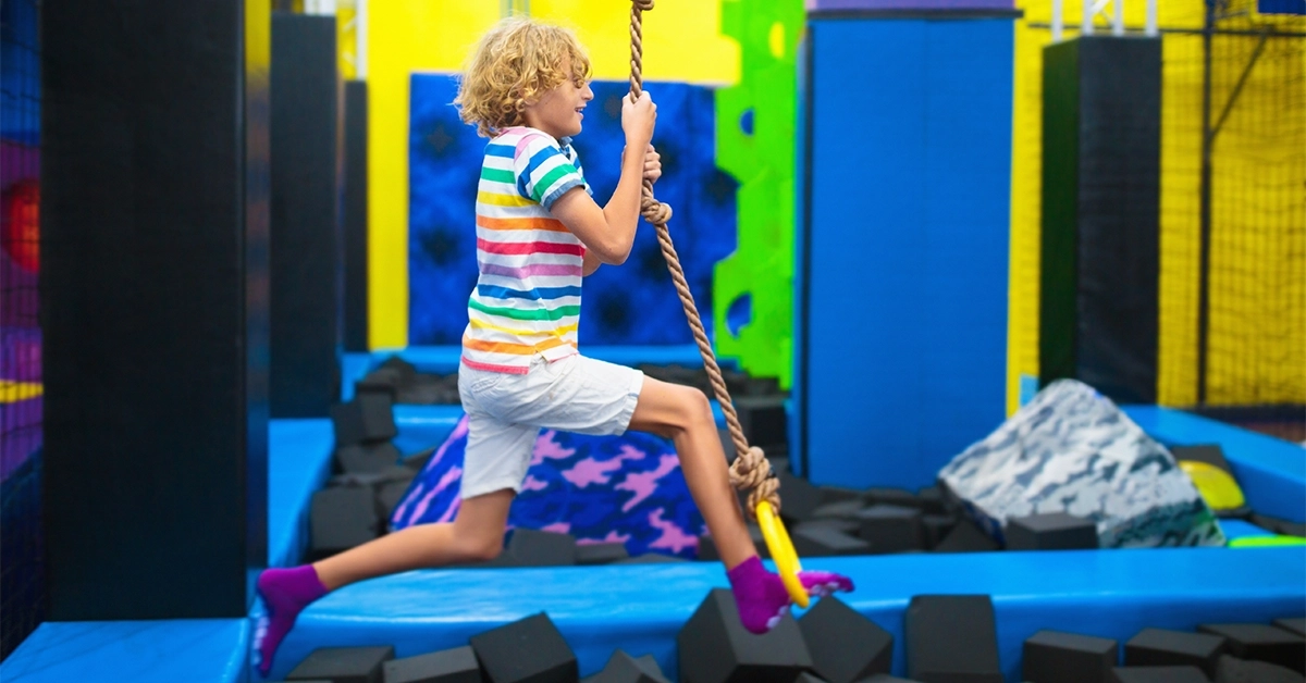 Kid jumping in trampoline park at street maniax