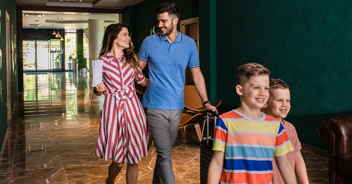 A smiling family in a hotel lobby near Dubai Production City