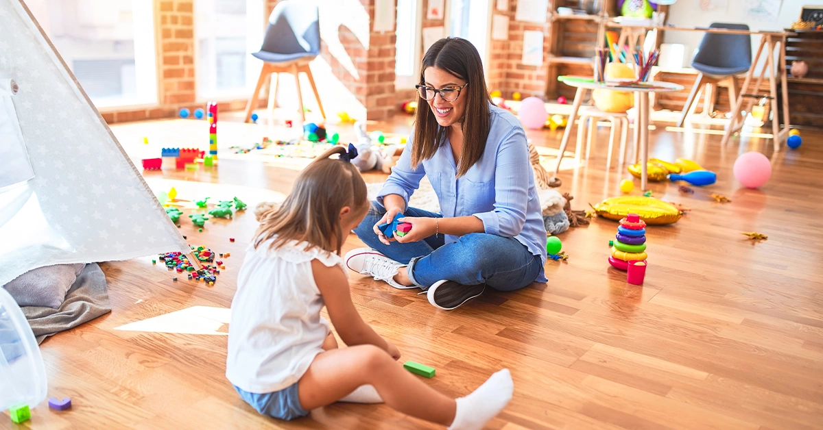 Teacher facilitating a kid in nursery in Deira