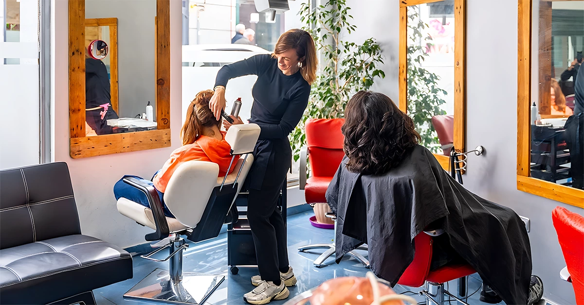 A hairdresser styling a client's hair in a beauty salon in Deira