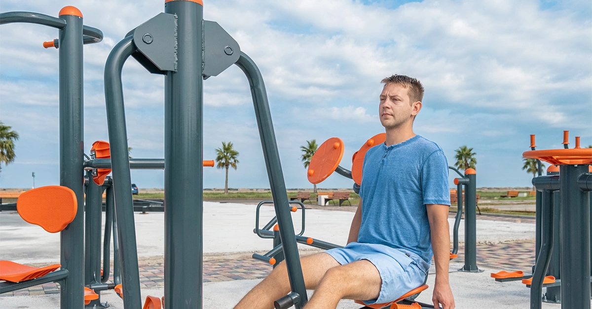 A man exercising at the outdoor gym at Al Mugheirah Bay