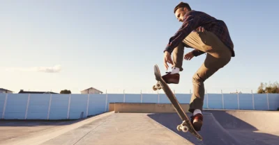 A young man skateboarding during the day at DAMAC Hills Skatepark​