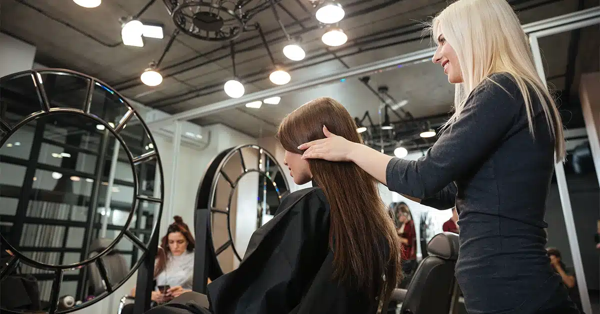 A hairdresser styling a woman's hair