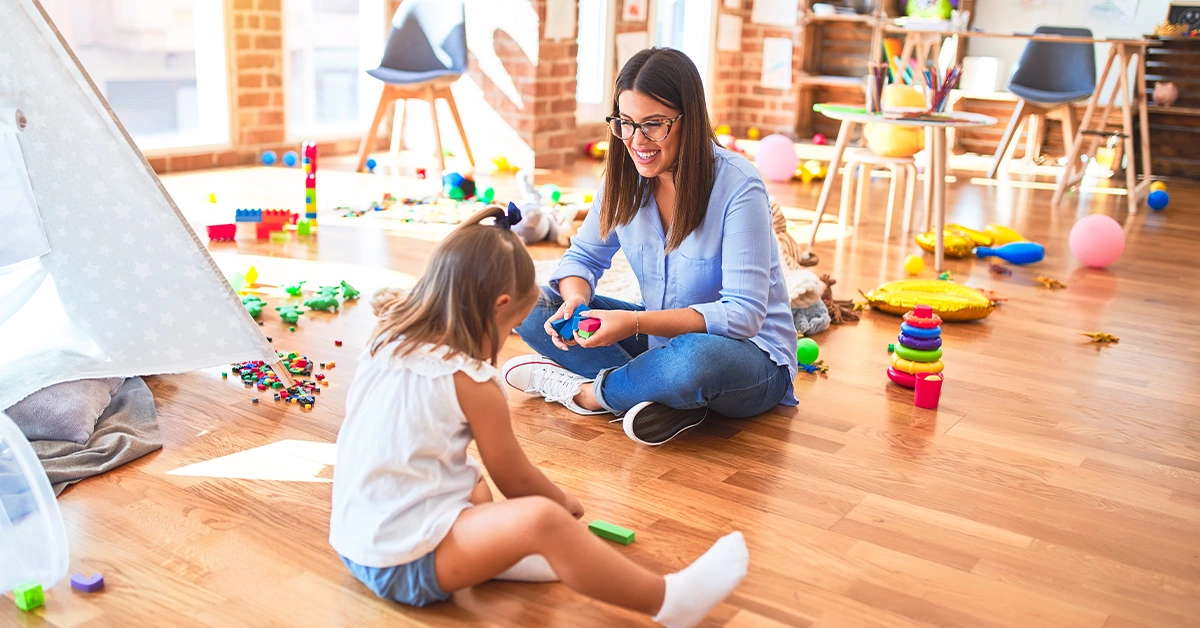 Teacher facilitating a kid in the nursery
