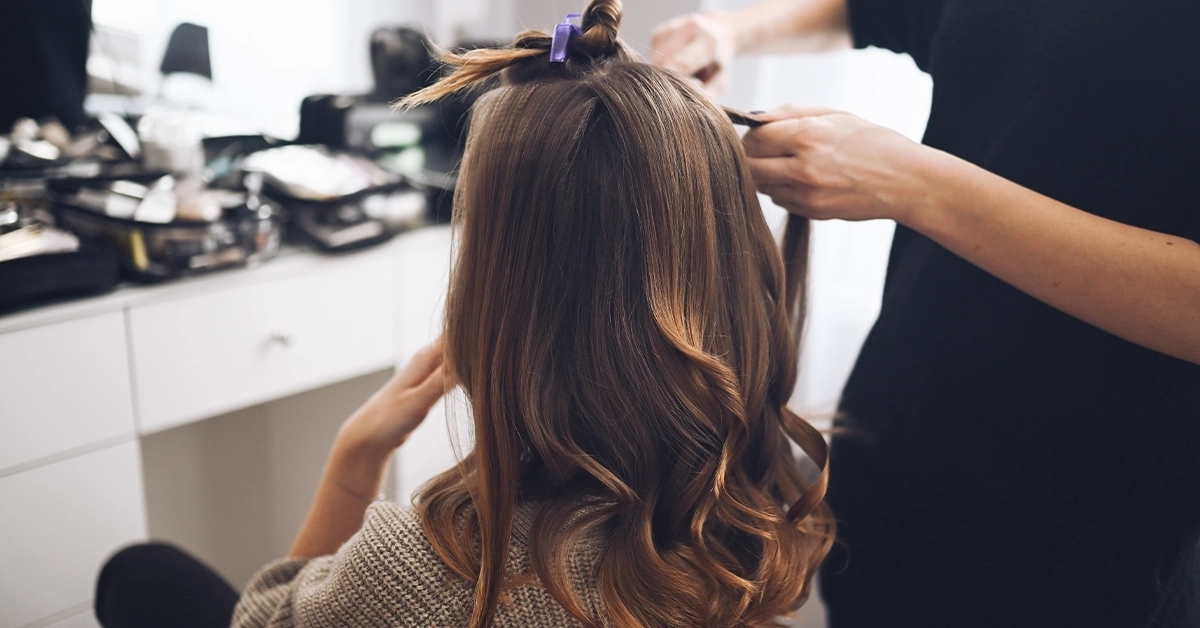 Hair Stylist Curling Client’s Hair