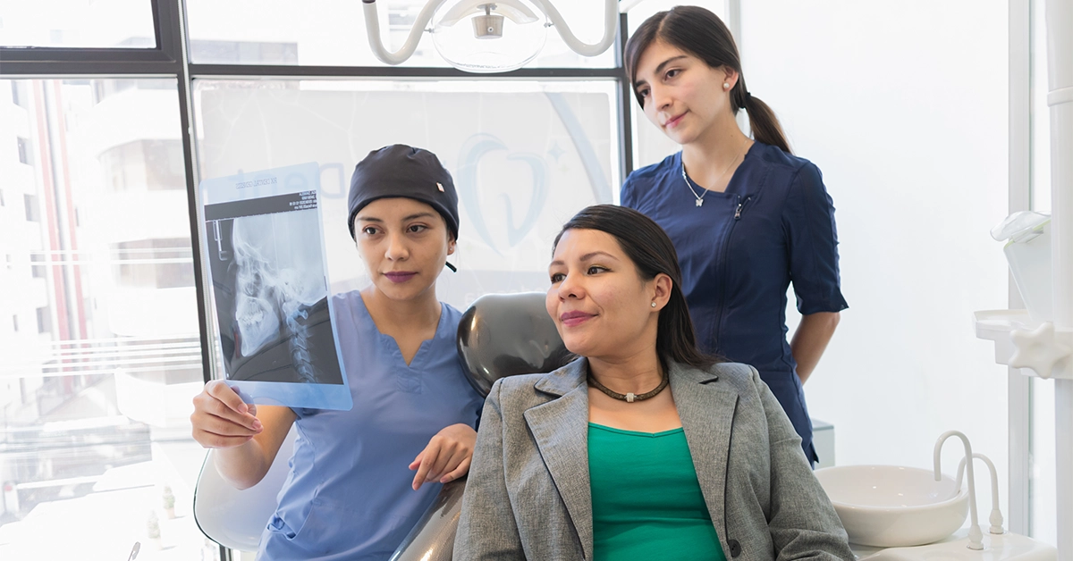 A female dentist checking X-ray of a patient