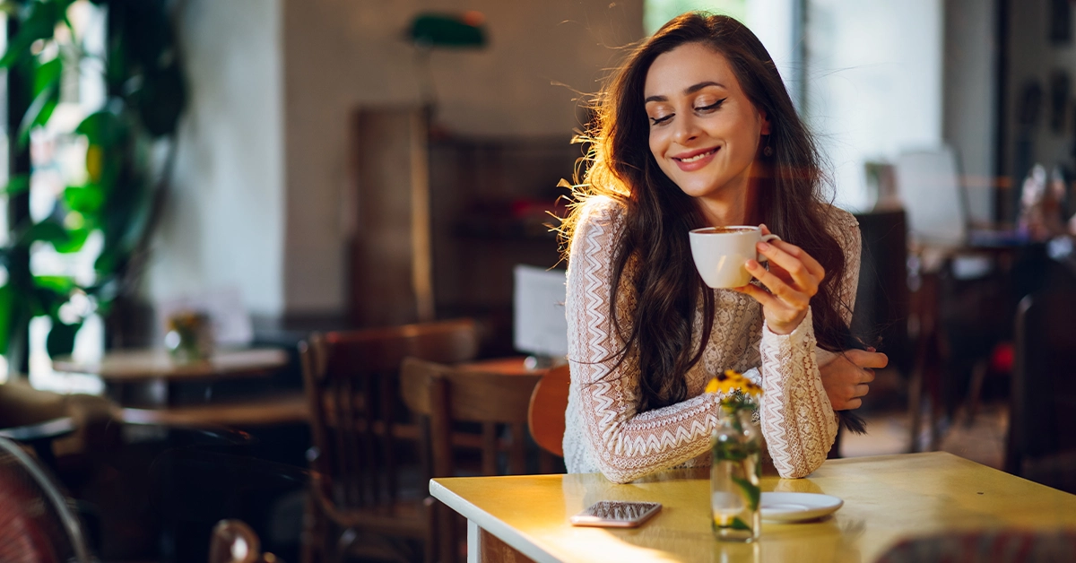 A woman enjoying a cup of coffee at a cafe