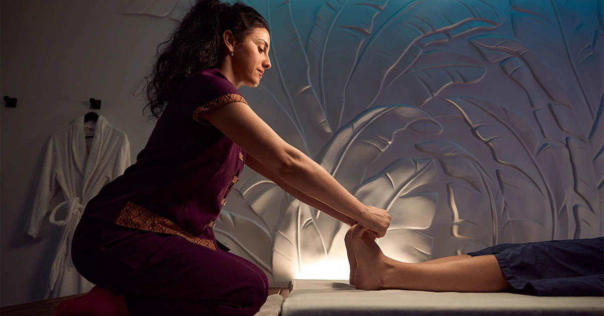 A masseuse giving Thai feet massage to a client