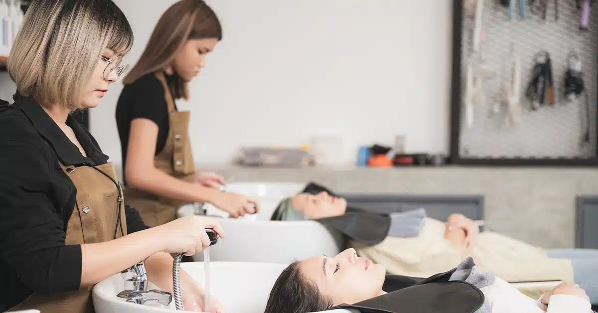 A hairdresser washing a client's hair