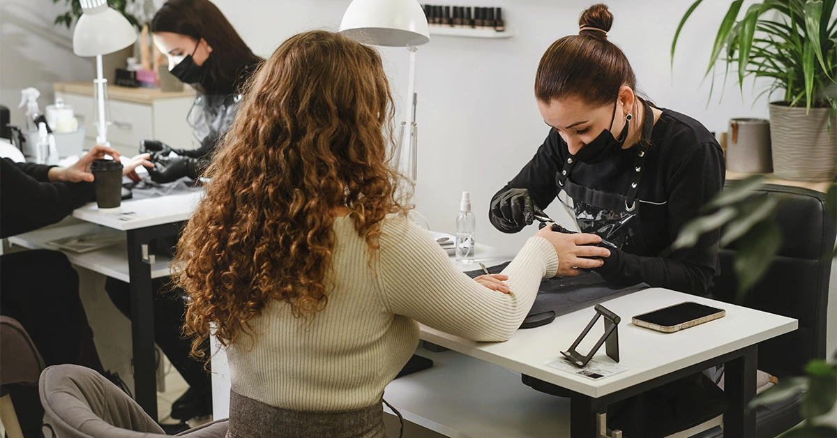 A nail stylist doing manicure