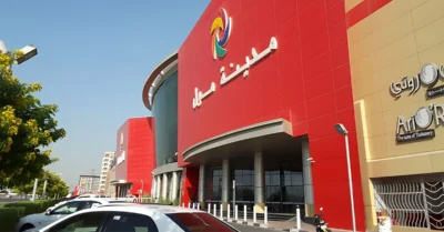 Happy young woman doing grocery shopping at hypermarket