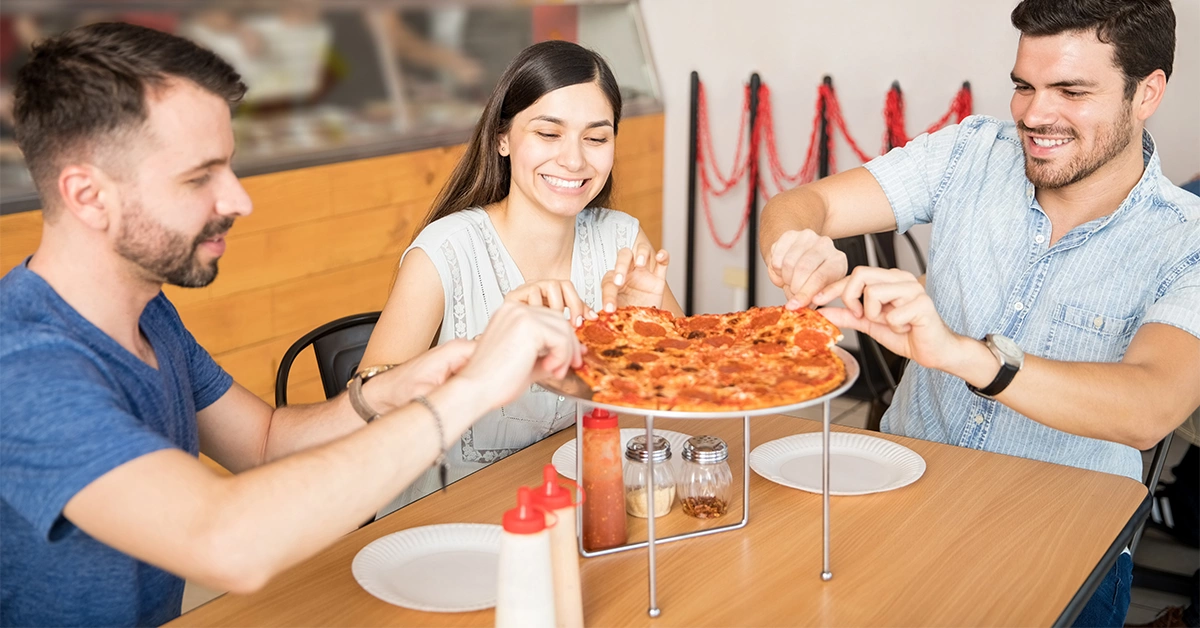 A group of friends enjoying pizza at Pizza Express Restaurant in City Center Fujairah