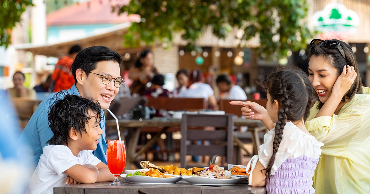 A happy Asian family enjoying a light meal at the best cafe with a play area in Dubai
